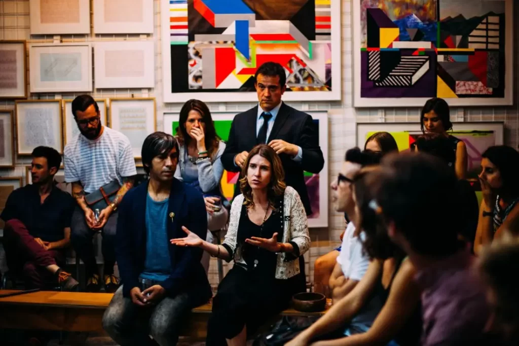 A woman with her hands up, explaining a topic to a group of people.